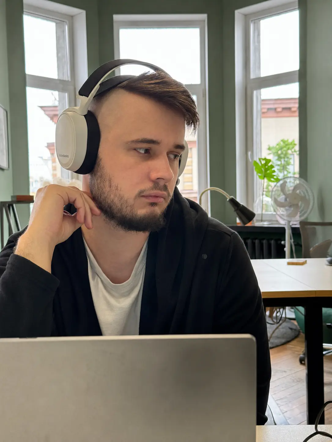 Алекс работает за ноутбуком в офисе